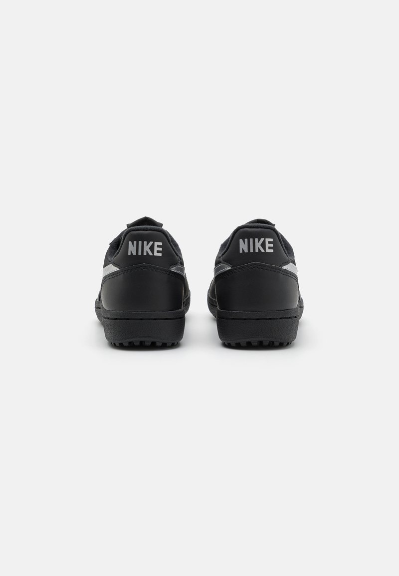 Scarpe Nike nere con tomaia in pelle sintetica, linguetta posteriore testurizzata e suola in gomma. Presentano un marchio grigio sul tallone.