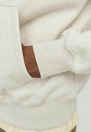 Light gray sweatshirt with a soft texture, featuring a kangaroo pocket and ribbed cuffs. A hand with dark skin is visible near the pocket.