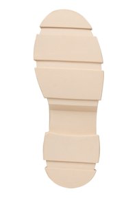 Suela de goma de color beige claro con secciones texturizadas y estriadas y bordes redondeados. Presenta un diseño segmentado y simplista para ofrecer agarre y comodidad.