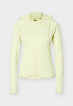 Vaalea keltainen pitkähihaisen hupullisen paidan, jossa on slim fit -leikkaus ja pieni valkoinen North Face -logo rinnassa.