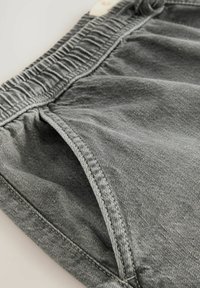 Șorturi din denim gri cu un talie elastică, dotate cu buzunare laterale și un finisaj moale, texturat. Detalii de cusătură pe margini.