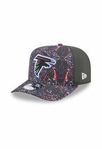 Casquette noire ornée d'un design de peinture éclaboussée dans des couleurs vives, avec un emblème de faucon brodé en évidence à l'avant.
