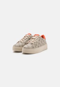 Beige patterned sneakers with elevated beige soles and orange accents at the heel and tongue. Features cream laces and textured fabric.