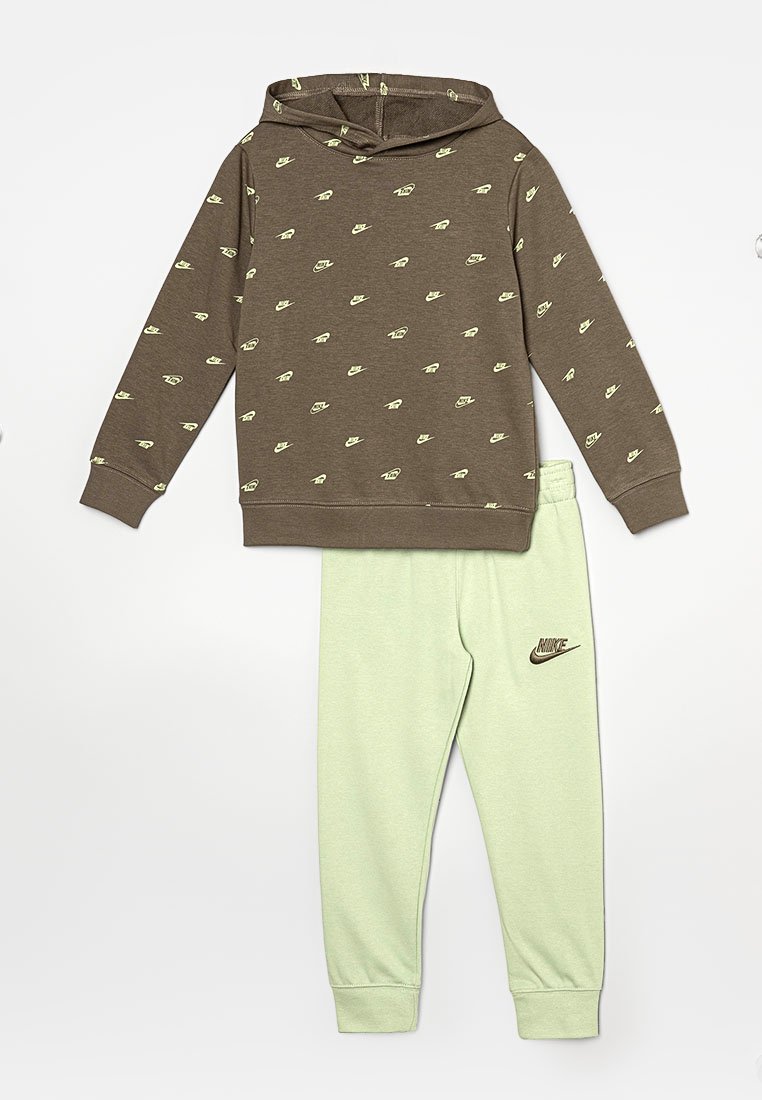 Felpa marrone con loghi Nike gialli, abbinata a pantaloni da jogging tapered verde chiaro con un piccolo logo Nike marrone. Tessuto morbido.