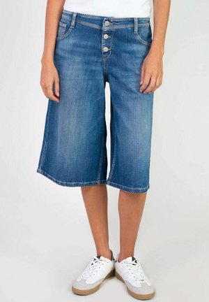 Denim culottes in light blue with a slight fade, featuring five-button closure, standard pockets, and a straight leg cut to the knee.