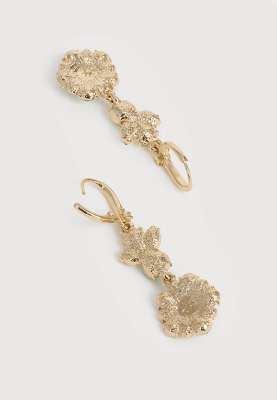 Σκουλαρίκια με κρεμαστά στοιχεία σε χρυσό τόνο, με υφασμένους λουλουδένιους και φυτικούς μοτίβους, με κλιπ αγκίστρου σε ουδέτερο φόντο.