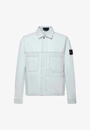 Giacca di denim azzurro chiaro con due tasche frontali sul petto, chiusura con bottoni, colletto e una toppa nera sulla manica sinistra.