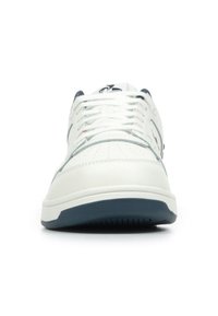 Sneakers bianchi in pelle con un accento blu navy, caratterizzati da una punta perforata, lacci bianchi e una suola texturizzata per una migliore aderenza.