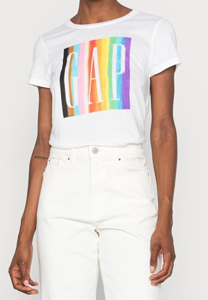 Wit katoenen T-shirt met een meerkleurige streepengrafiek en "GAP" in dikke witte letters. Korte mouwen en een losse pasvorm.