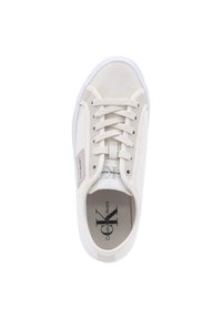 Sneaker bianca in tela con superficie testurizzata, punte rotonde e suola in gomma bianca. Presenta una chiusura con lacci sul davanti e un'etichetta con logo di lato.