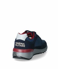 Sneaker in suede navy con suola grigia e dettagli rossi. Presenta il logo "MARINA MILITARE" sul tallone. Design con lacci e colletto imbottito.