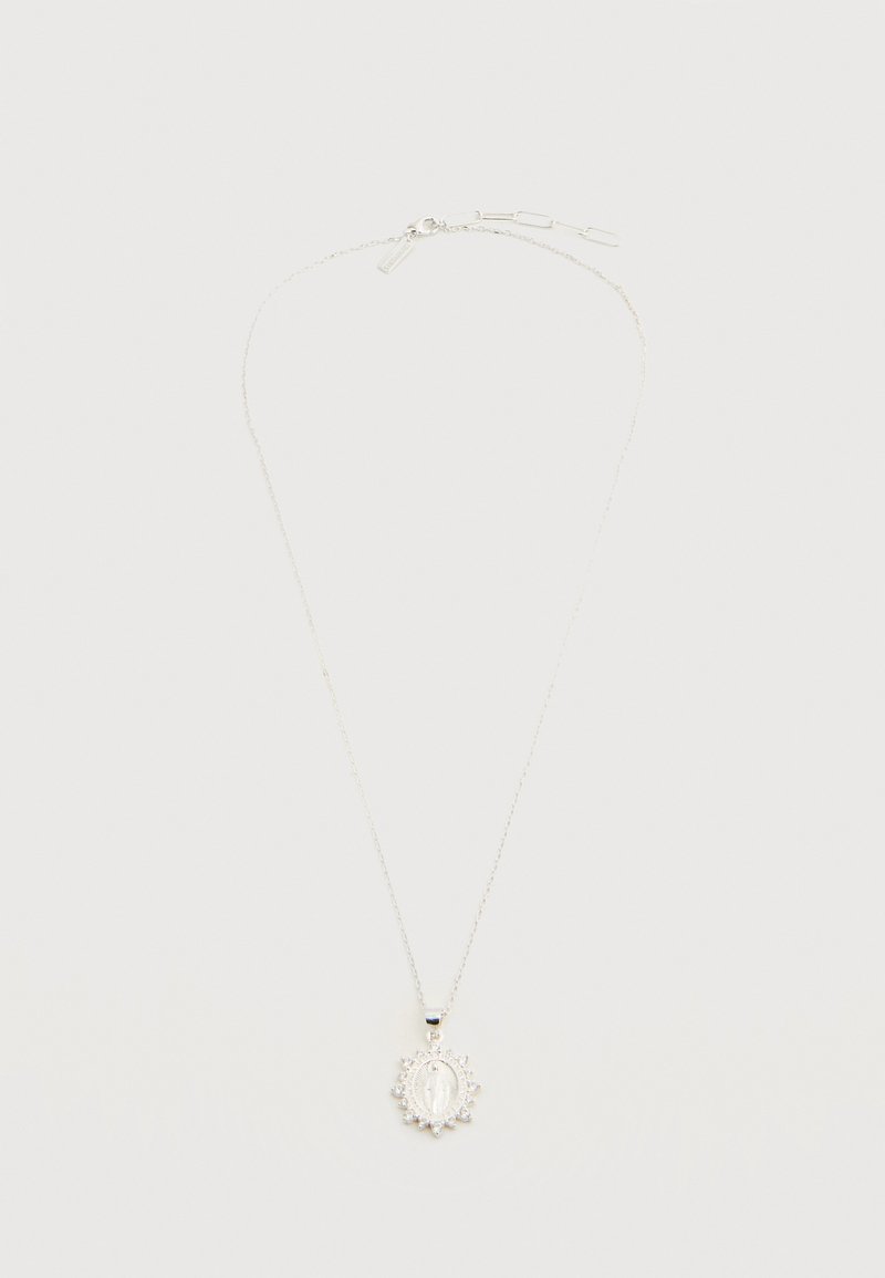 Λεπτό ασημένιο κολιέ με οβάλ θρησκευτικό μενταγιόν που απεικονίζει ανάγλυφη φιγούρα και περιβάλλεται από μικρές διακοσμητικές πέτρες.