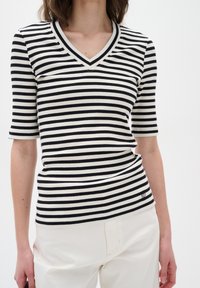 Černobílý pruhovaný ribbed top s krátkým rukávem a véčkovým výstřihem, se štíhlým střihem a malou logovou detailou na lemu.