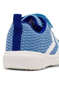 Niebieski sportowy but z siateczkowej cholewki z teksturą, białą gumową podeszwą i niebieskim paskiem. Posiada wzmocnioną piętę i detal logo na podeszwie.