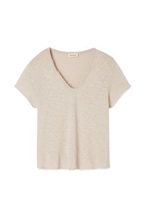 Beige t-paita, jossa on V-pääntie ja lyhyet hihat, valmistettu pehmeästä materiaalista, jossa on hienovarainen tekstuurikuvio ja raakamaalattu pääntie.