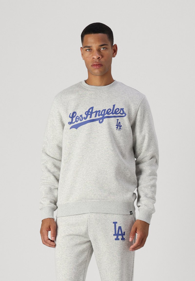 Gray sweatshirt with blue "Los Angeles" script and "LA" logo. Crew neck, ribbed cuffs, and waistband. Paired with matching gray pants.