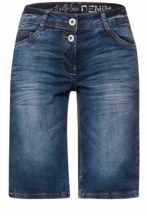Zbliżenie na niebieskie dżinsy z denimu, pokazujące przednią kieszeń, nit i żółte przeszycia na teksturowanej tkaninie.