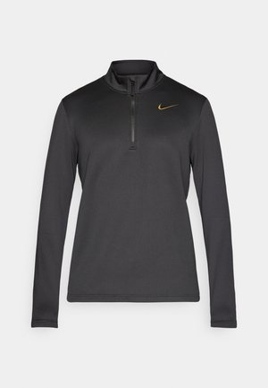 Sort langærmet pullover med halv-zip krave, der har en tekstureret stof og et lille guld Nike-logo på venstre bryst.