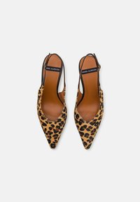 Tacones slingback con estampado de leopardo, puntas afiladas, tiras negras y una plantilla color tostado. Hechos de tejido texturizado con un forro de cuero suave.