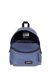Sac à dos bleu avec une surface texturée, une poignée supérieure, une fermeture éclair et une étiquette intérieure. Il dispose d'une poche avant et d'un design arrondi.