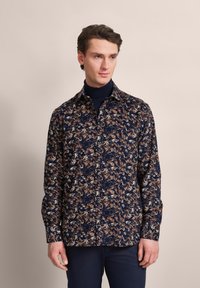 Marinefarbendes Hemd mit Knopfleiste, das ein Blumendesign in Brauntönen und Cremetönen aufweist. Es besteht aus leichtem Stoff und hat einen klassischen Kragen sowie lange Ärmel.