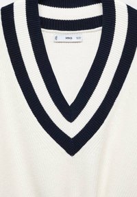 Pull en maille blanc avec un col en V profond présentant deux rayures côtelées bleu marine et une petite étiquette de marque blanche à l'intérieur du col.