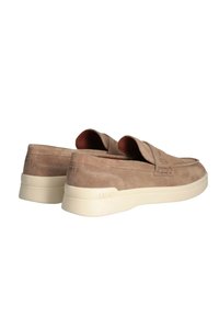 Scarpe slip-on in suede beige con profilo basso, texture morbida e suola in gomma crema; presenta logo in rilievo e dettagli cuciti.