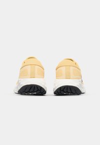 Yellow athletic shoes featuring a textured mesh upper, padded collar, and a white midsole with black rubber outsole.