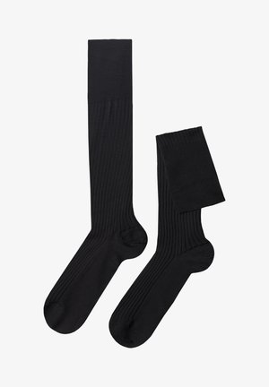 Calze nere a coste con una texture liscia, dotate di un gambale alto e una coppia più corta. Realizzate in un materiale flessibile e leggero.