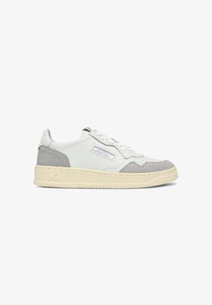 Sneaker basse con tomaia in pelle bianca, dettagli in suede grigio chiaro sulla punta e sul tallone, suola beige e toppa marchiata sul lato.