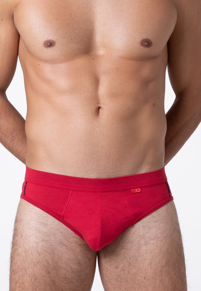 Slip di cotone rosso con dettagli laterali a contrasto, caratterizzati da un'ampia vita e una texture liscia. Il design è aderente, enfatizzando la forma.