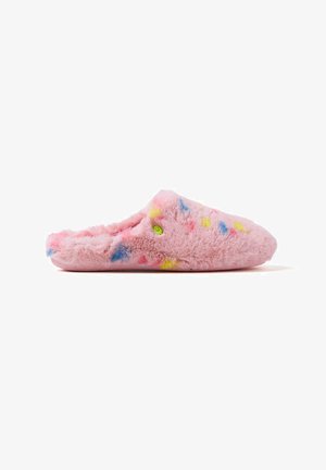 Zapatilla rosa esponjosa con una textura suave, presenta salpicaduras coloridas en amarillo, azul y rojo, y un diseño sin cordones para facilitar su uso.