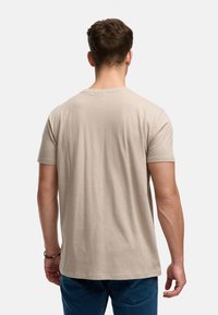 Beige Baumwoll-T-Shirt mit Rundhalsausschnitt, kurzen Ärmeln und geradem Saum, von hinten gezeigt, mit einer glatten Textur.