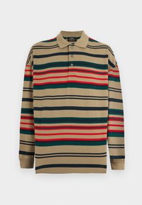 Μπεζ πόλο πουκάμισο με μακριά μανίκια, με οριζόντιες πράσινες, κόκκινες και μαύρες ρίγες και τρία κουμπιά στον γιακά.