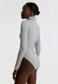 Grauer, gerippter Turtleneck-Bodysuit mit langen Ärmeln, der eng anliegt und eine vertikale Struktur aufweist, entworfen für eine schmal geschnittene Silhouette.
