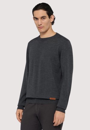 Dunkelgrauer Rundhalspulli aus weichem Material, mit gerippten Bündchen und Saum, und einem kleinen braunen Lederlogo-Akzent am unteren Rand.