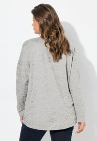 Lichtgrijze long-sleeve top met een gestructureerd slangenprintpatroon, met een ontspannen pasvorm en een afgeronde zoom.
