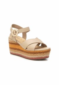 Sandali con zeppa beige, dotati di cinturini incrociati, una fibbia rotonda e una piattaforma intrecciata testurizzata multicolore con tonalità dorate, arancioni e rosa.