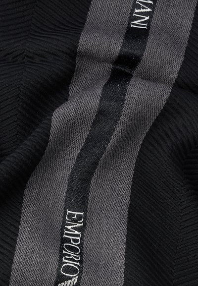 Črno in sivo teksturirano blago s ribjo kostjo vzorcem. Vsebuje črto iz črnega satena z vezenim napisom "EMPORIO ARMANI" v beli barvi.
