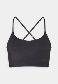 Bralette noir avec une texture lisse, dotée de fines bretelles qui se croisent dans le dos et d'un design simple, sans embellissements.