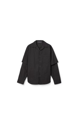 Camicia nera a maniche lunghe con bottoni, maniche corte sovrapposte e taschino sul petto, mostrata su sfondo bianco.