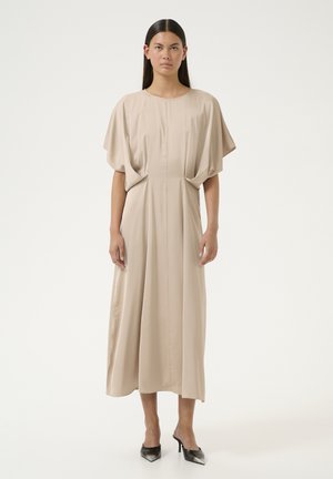 Beige midi-mekko, jossa on lyhyet, leveät hihat, pyöreä pääntie ja laskokset vyötäröllä. Sujuva kangas ja rento siluetti. Mustat korot.