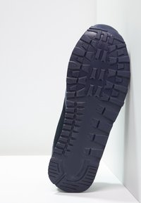 Sula av gummi med textur, djupa mönster och en något upphöjd kant. Mörk marinblå färg, designad för grepp och hållbarhet.