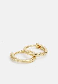 Boucles d'oreilles en or avec un design lisse et arrondi et un fermoir. La surface métallique brillante reflète la lumière, mettant en valeur l'apparence générale.