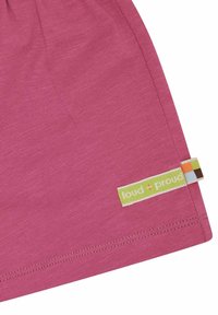 Rosa Baumwoll-T-Shirt mit abgerundetem Saum, weichem Material und einem "loud + proud"-Label mit einem mehrfarbigen Muster in der Nähe der Naht.