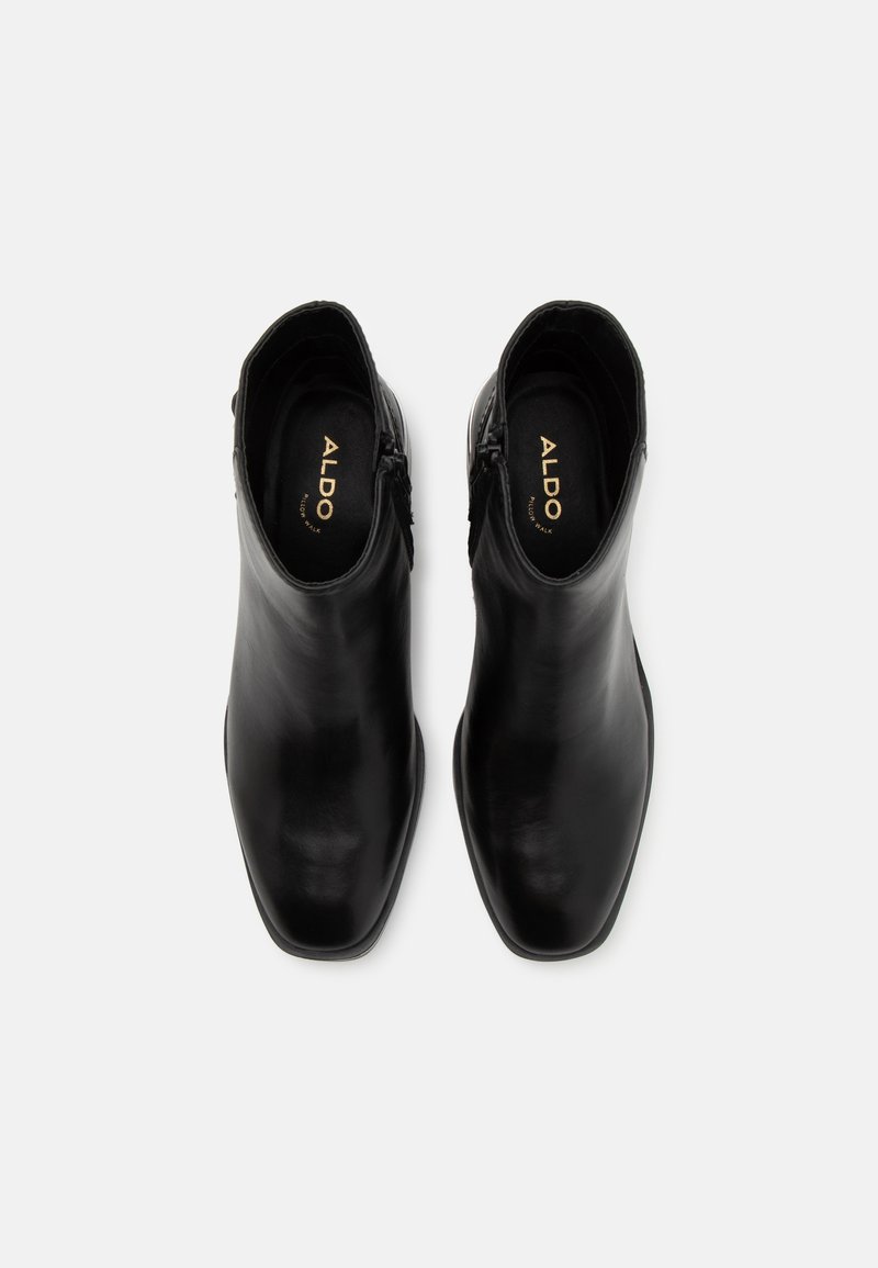 Botines de cuero negro hasta el tobillo con un diseño de punta afilada, acabado elegante y cierre con cremallera lateral, con el nombre de la marca "ALDO" en el interior.