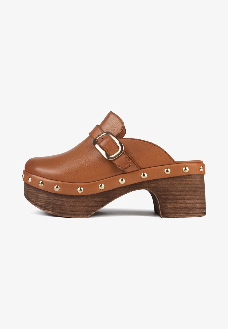 Brown leather clog with a wide strap and a gold buckle, featuring a wooden heel and brass studs along the sole. Smooth texture and rounded shape.