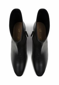 Schwarze Lederstiefeletten mit schlankem Design, spitzem Schuhschnitt und Seitenreißverschlüssen. Glatte Textur mit minimalen Nähten.