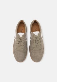 Sneakers in suede grigio con strisce bianche e verde oliva, dotate di lacci tondi e dettagli perforati sulla punta. Suola in gomma piatta.