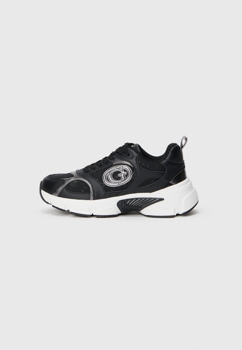 Mustad mustatakse Sneaker, mille pealmine osa on tekstuuriga nahast, valge talla, hõbedaste aktsentide ja logoga sildi ots.